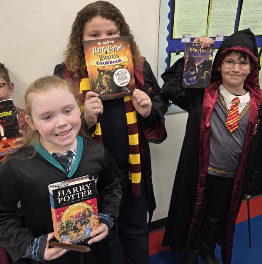 3 students in Harry Potter costumes, smiling